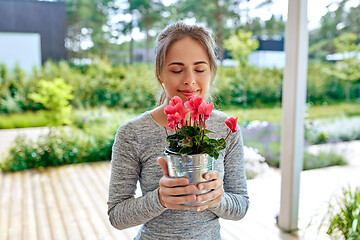 Image showing young woman with cyclamen flowers at summer garden