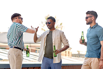 Image showing happy male friends drinking beer at rooftop party