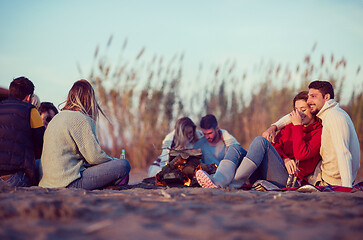 Image showing Couple enjoying with friends at sunset on the beach