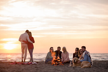 Image showing Couple enjoying with friends at sunset on the beach