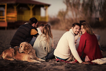 Image showing Couple enjoying with friends at sunset on the beach