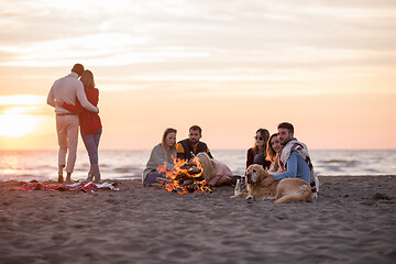 Image showing Couple enjoying with friends at sunset on the beach