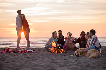 Image showing Couple enjoying with friends at sunset on the beach