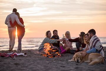 Image showing Couple enjoying with friends at sunset on the beach