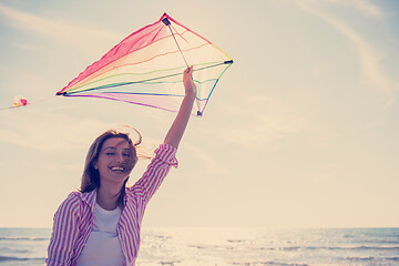 Image showing Young Woman with kite at beach on autumn day