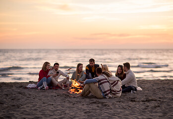 Image showing Group Of Young Friends Sitting By The Fire at beach