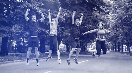 Image showing runners team jumping in the air during  morning training