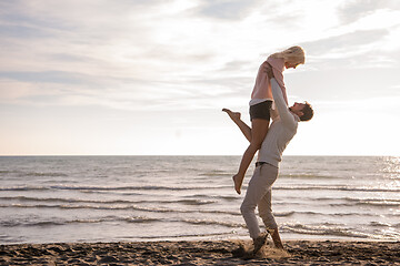 Image showing Loving young couple on a beach at autumn sunny day