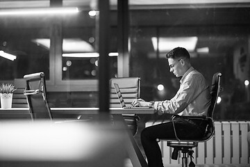 Image showing man working on laptop in dark office