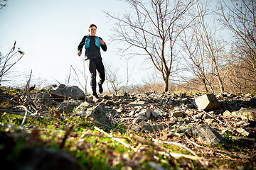 Image showing Man running in a park or forest against trees background.