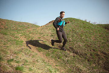 Image showing Man running in a park or forest against trees background.