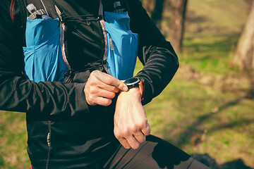 Image showing Man preparing tu run in a park or forest against trees background.