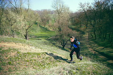 Image showing Man running in a park or forest against trees background.