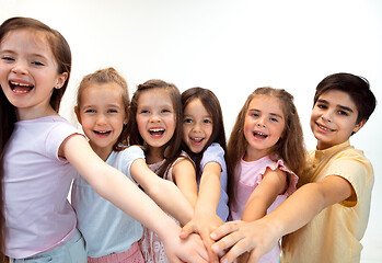 Image showing The portrait of cute little boy and girls in stylish clothes looking at camera at studio