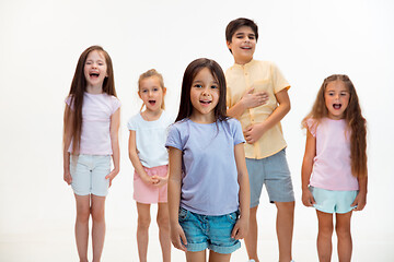 Image showing The portrait of cute little boys and girls in stylish clothes looking at camera at studio