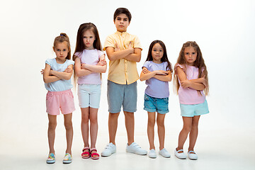 Image showing The portrait of cute little boys and girls in stylish clothes looking at camera at studio