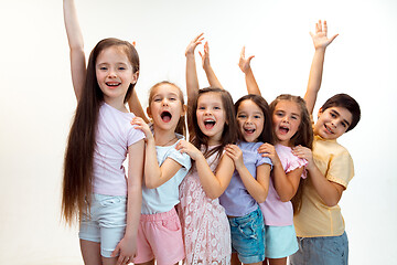 Image showing The portrait of cute little boy and girls in stylish clothes looking at camera at studio