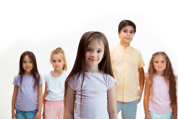 Image showing The portrait of cute little boys and girls in stylish clothes looking at camera at studio