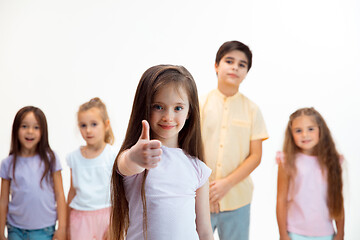 Image showing The portrait of cute little boys and girls in stylish clothes looking at camera at studio