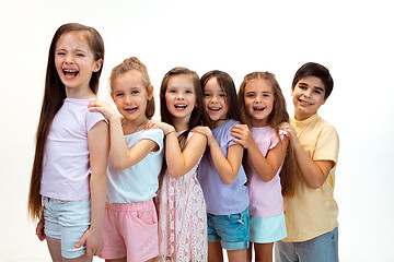 Image showing The portrait of cute little boy and girls in stylish clothes looking at camera at studio