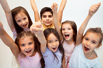 Image showing The portrait of cute little boy and girls in stylish clothes looking at camera at studio