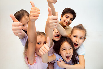 Image showing The portrait of cute little boy and girls in stylish clothes looking at camera at studio