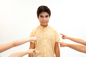 Image showing Little boy standing alone and suffering an act of bullying.