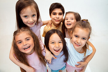 Image showing The portrait of cute little boy and girls in stylish clothes looking at camera at studio