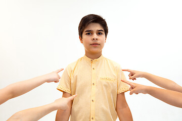 Image showing Little boy standing alone and suffering an act of bullying.