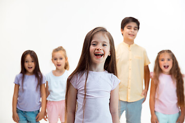 Image showing The portrait of cute little boys and girls in stylish clothes looking at camera at studio