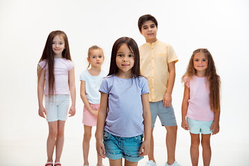 Image showing The portrait of cute little boys and girls in stylish clothes looking at camera at studio