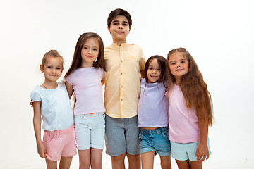 Image showing The portrait of cute little boys and girls in stylish clothes looking at camera at studio