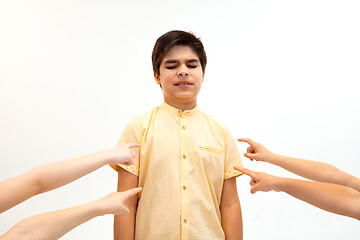 Image showing Little boy standing alone and suffering an act of bullying.