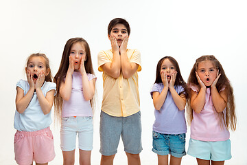 Image showing The portrait of cute little boys and girls in stylish clothes looking at camera at studio