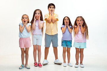 Image showing The portrait of cute little boys and girls in stylish clothes looking at camera at studio