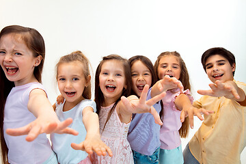 Image showing The portrait of cute little boy and girls in stylish clothes looking at camera at studio