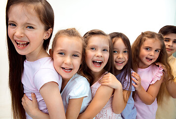 Image showing The portrait of cute little boy and girls in stylish clothes looking at camera at studio