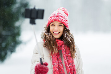 Image showing young woman taking selfie by monopod in winter