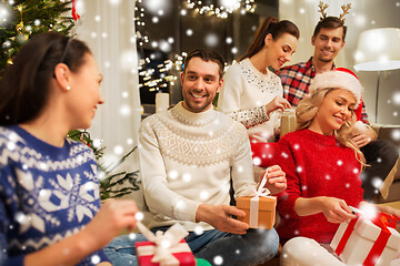 Image showing friends celebrating christmas and opening presents