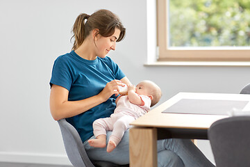 Image showing mother feeding baby daughter with milk formula