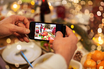 Image showing hands photographing food at christmas dinner