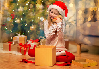 Image showing smiling girl in santa hat with christmas gift