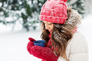 Image showing happy young woman with tea cup in winter park