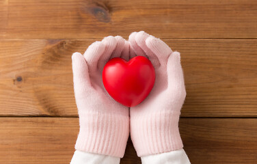 Image showing hands in pink woollen gloves holding red heart