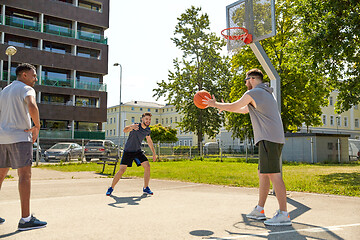 Image showing group of male friends playing street basketball