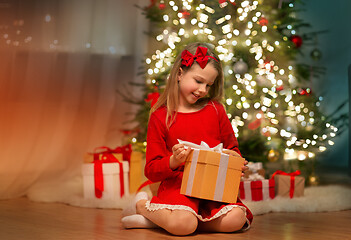 Image showing smiling girl with christmas gift at home