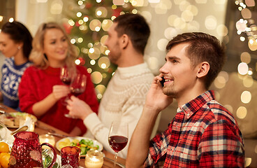 Image showing man calling on smartphone at christmas dinner