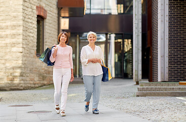 Image showing senior women with shopping bags walking in city