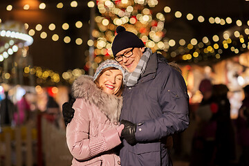 Image showing happy senior couple hugging at christmas market