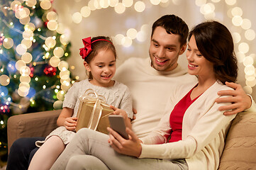 Image showing family with smartphone at home on christmas